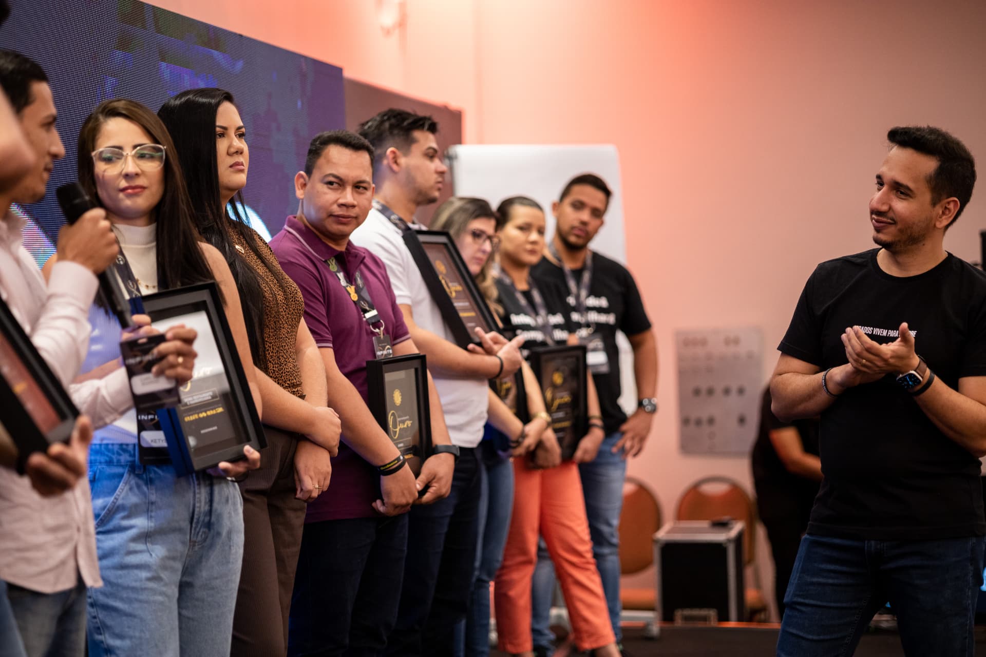 Empresários do Infinite recebendo o troféu Restaurante Ouro no palco