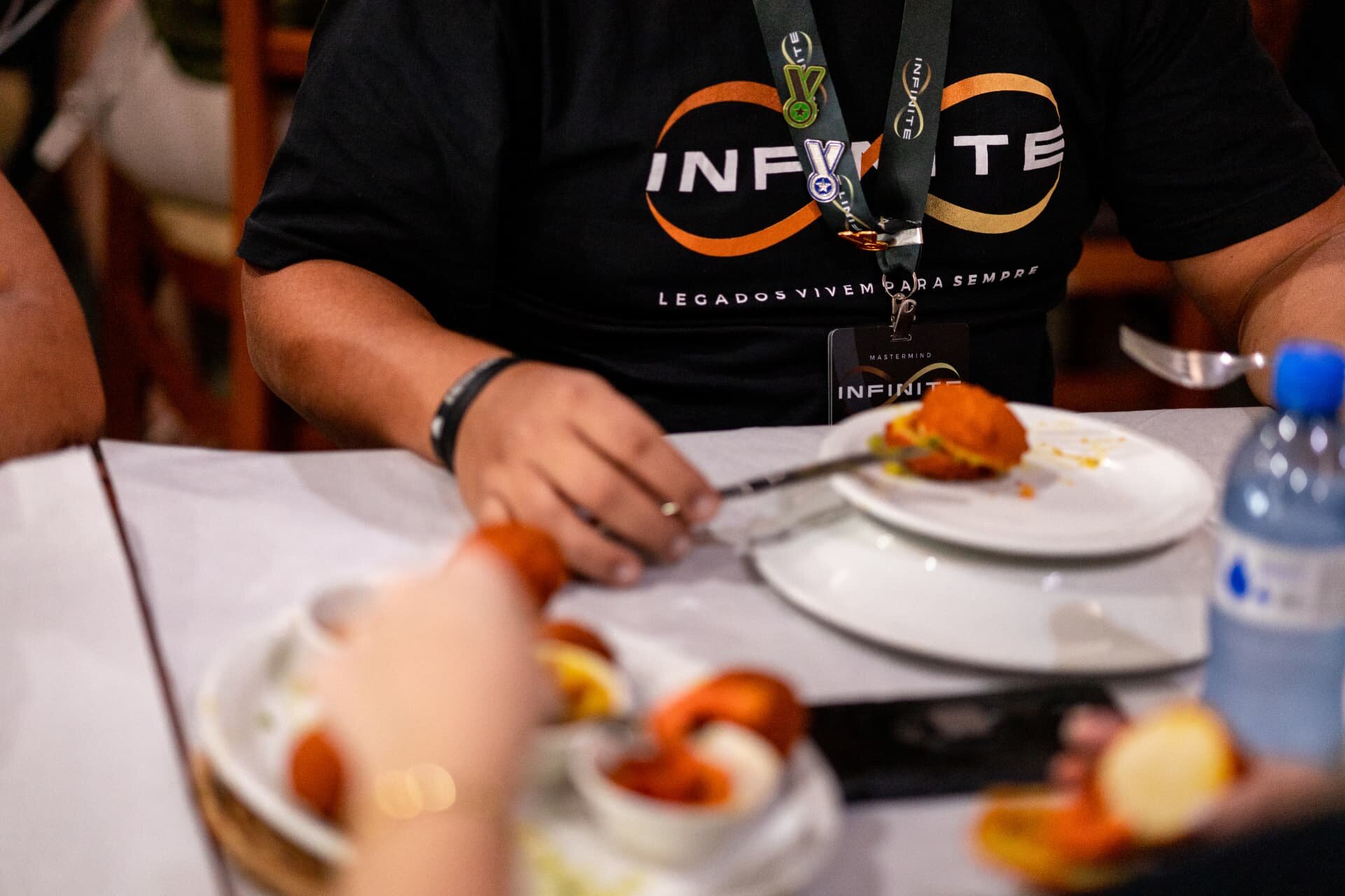 Participante com camiseta e crachá Infinite durante experiência gastronômica