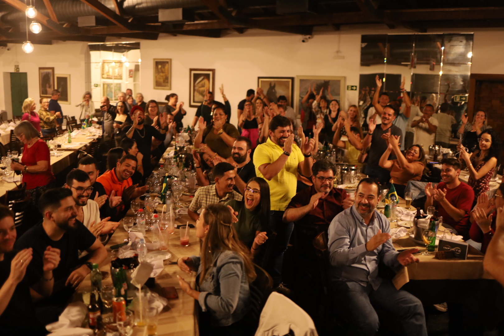 Empresários aplaudindo durante jantar de encontro do Infinite